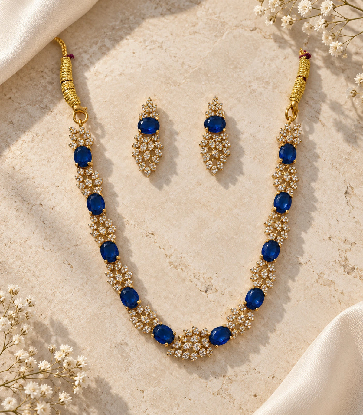 Gold Sapphire Round Crystal Necklace Set with matching earrings in a styled flatlay