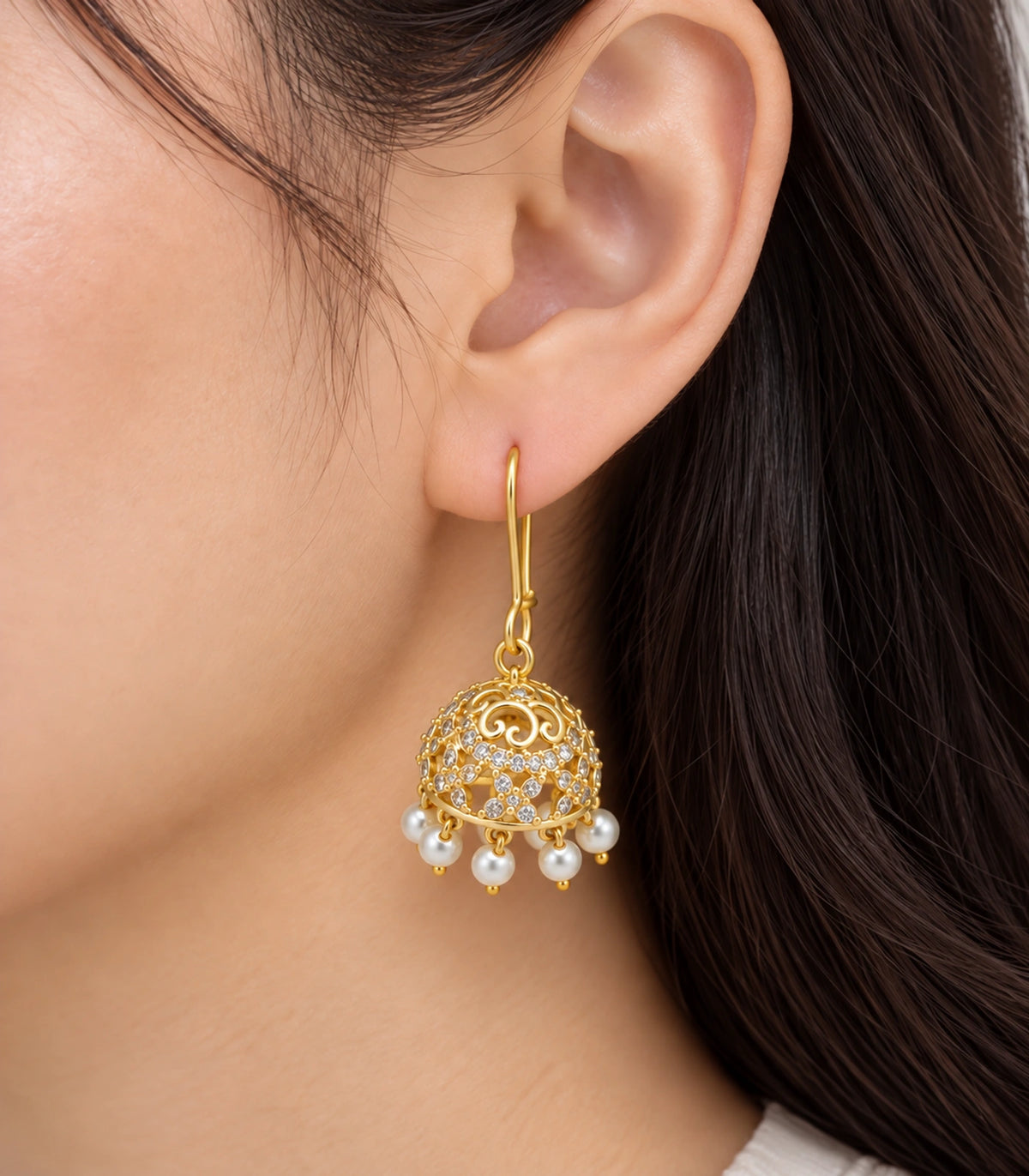Gold Scrollwork Crystal Jhumka Earrings in Gold — close-up of scrollwork dome and pearl-effect fringe worn at the ear #color_gold