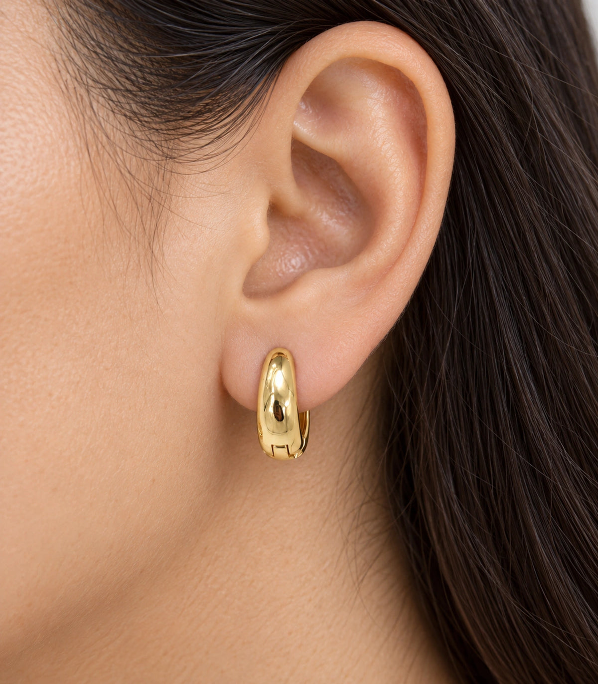 JIMIKI Smooth Tapered Huggie Earrings in Gold Tone — worn close-up detail #color_gold-tone