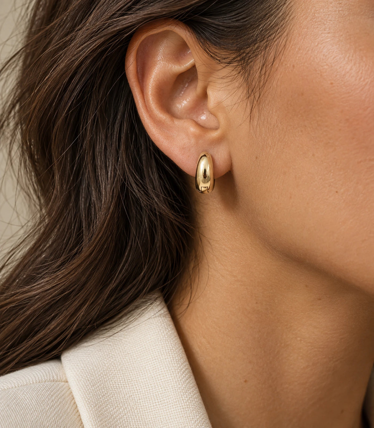 JIMIKI Smooth Tapered Huggie Earrings in Gold Tone — editorial worn styling #color_gold-tone