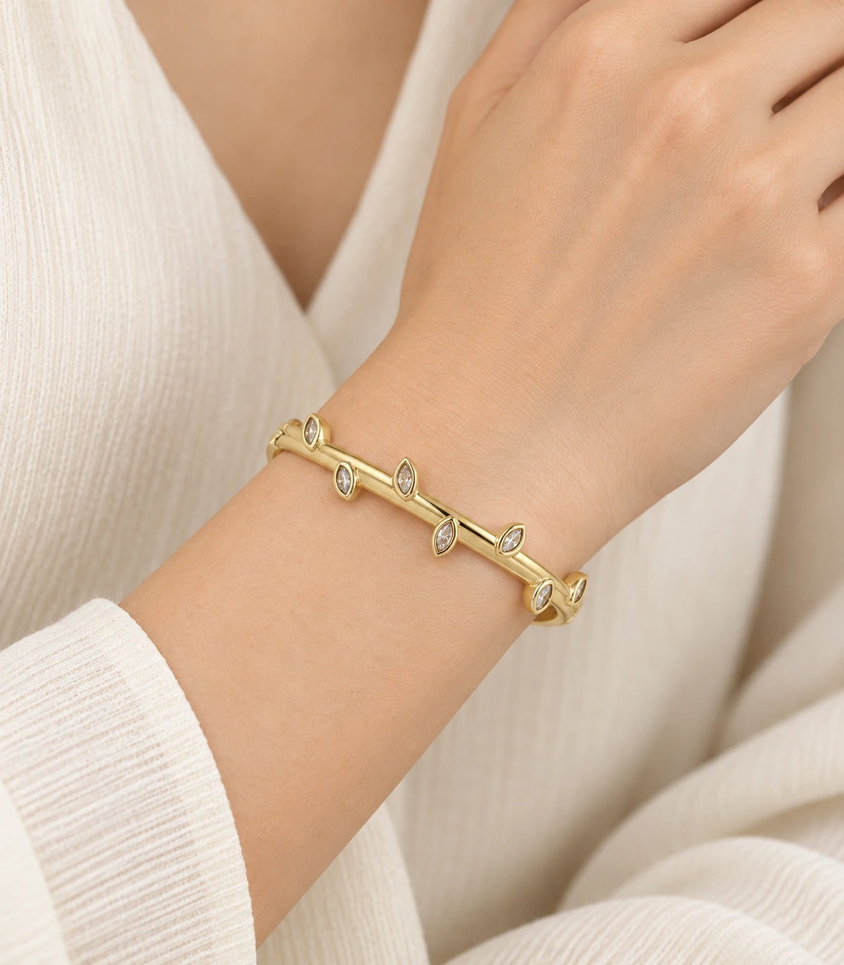 JIMIKI Gold-Tone Alternating Marquise Crystal Bangle — worn on the wrist #color_gold-tone / clear