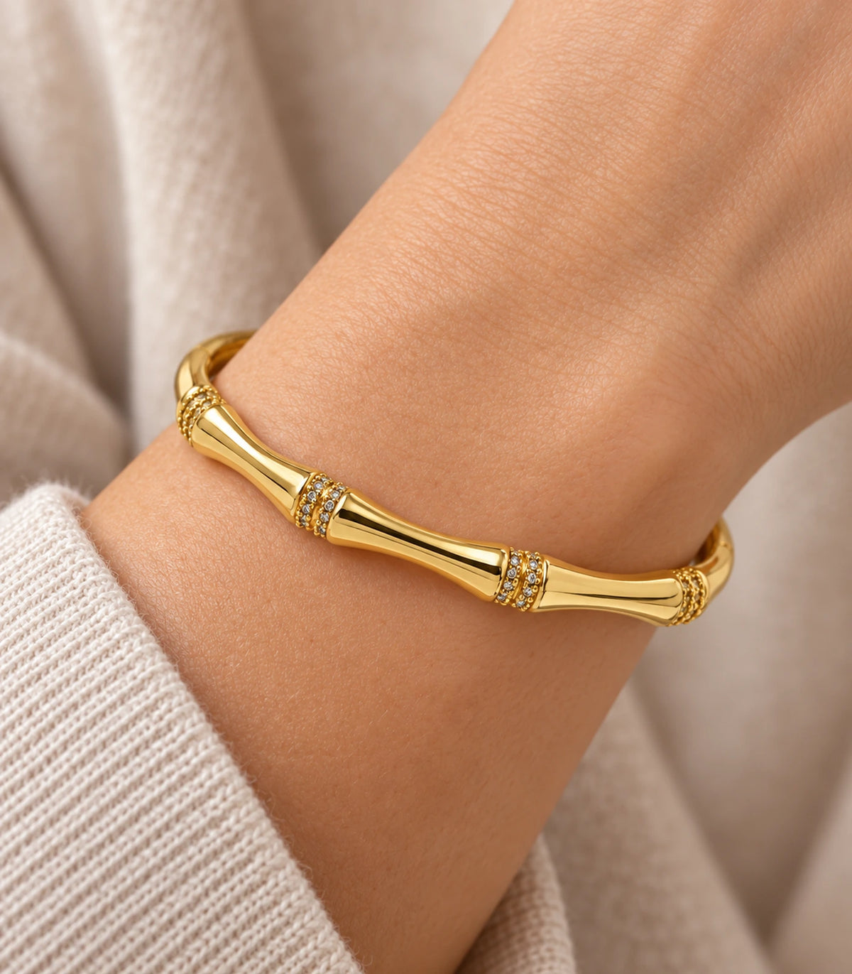 JIMIKI Gold-Tone Bamboo Crystal Collar Bangle — close-up of the bangle worn on the wrist #color_gold-tone / clear
