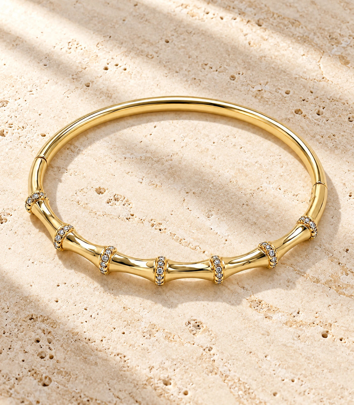 JIMIKI Gold-Tone Bamboo Pavé Collar Bangle — bangle in a styled flat lay #color_gold-tone / clear