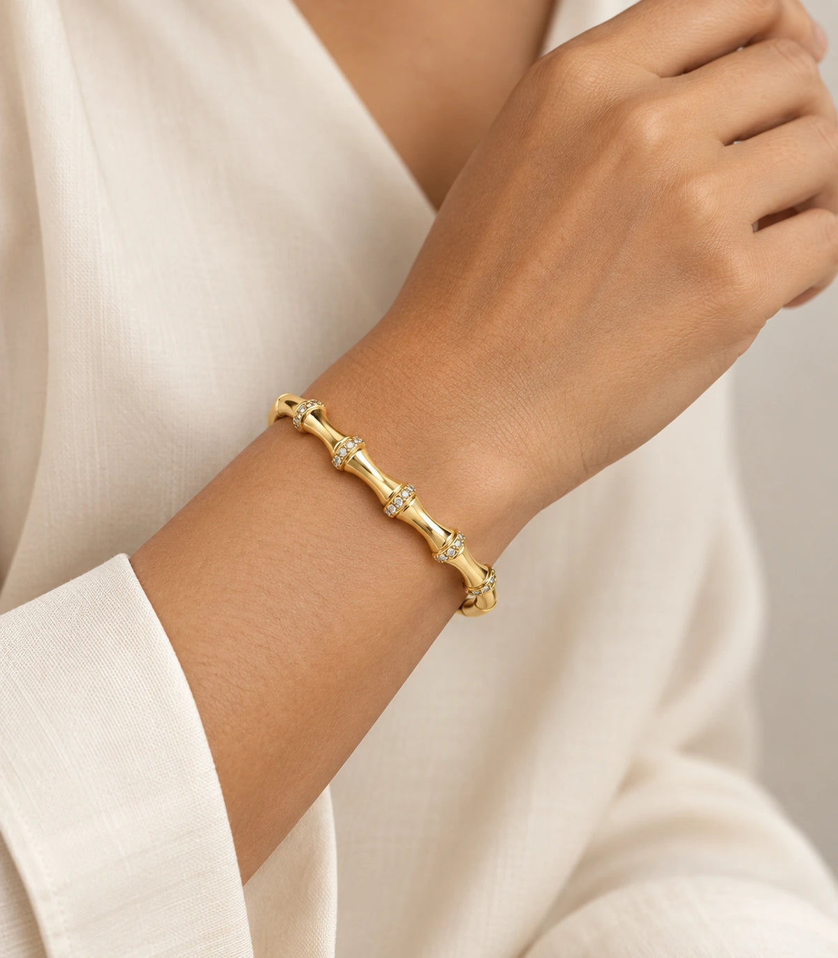 JIMIKI Gold-Tone Bamboo Pavé Collar Bangle — worn on the wrist #color_gold-tone / clear