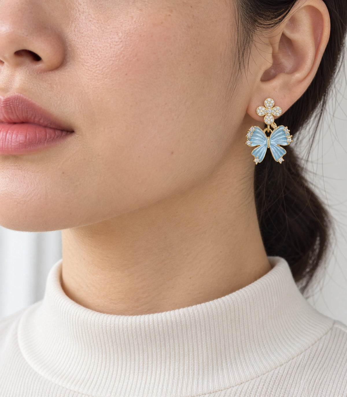 JIMIKI Butterfly Crystal Flower Drop Earring Pair in Gold tone / Blue, model wearing view #color_gold tone / blue