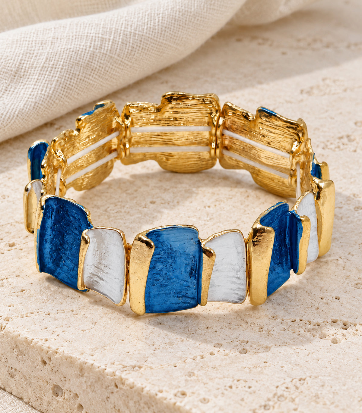 JIMIKI gold-tone blue and white rectangle panel bracelet — editorial flatlay