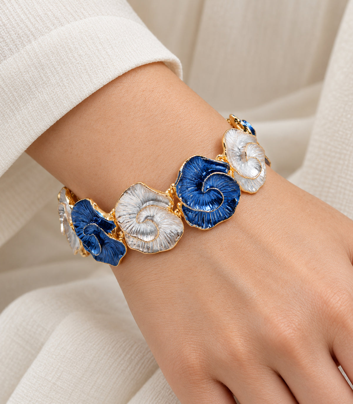 Gold-tone blue and white spiral-shell bracelet — closeup view