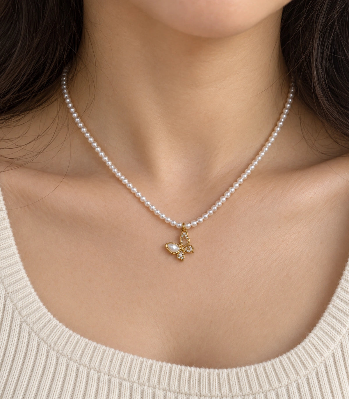 JIMIKI Gold-Tone Butterfly Pearl Necklace in Gold-tone / white, close-up of the pendant and pearl-style strand