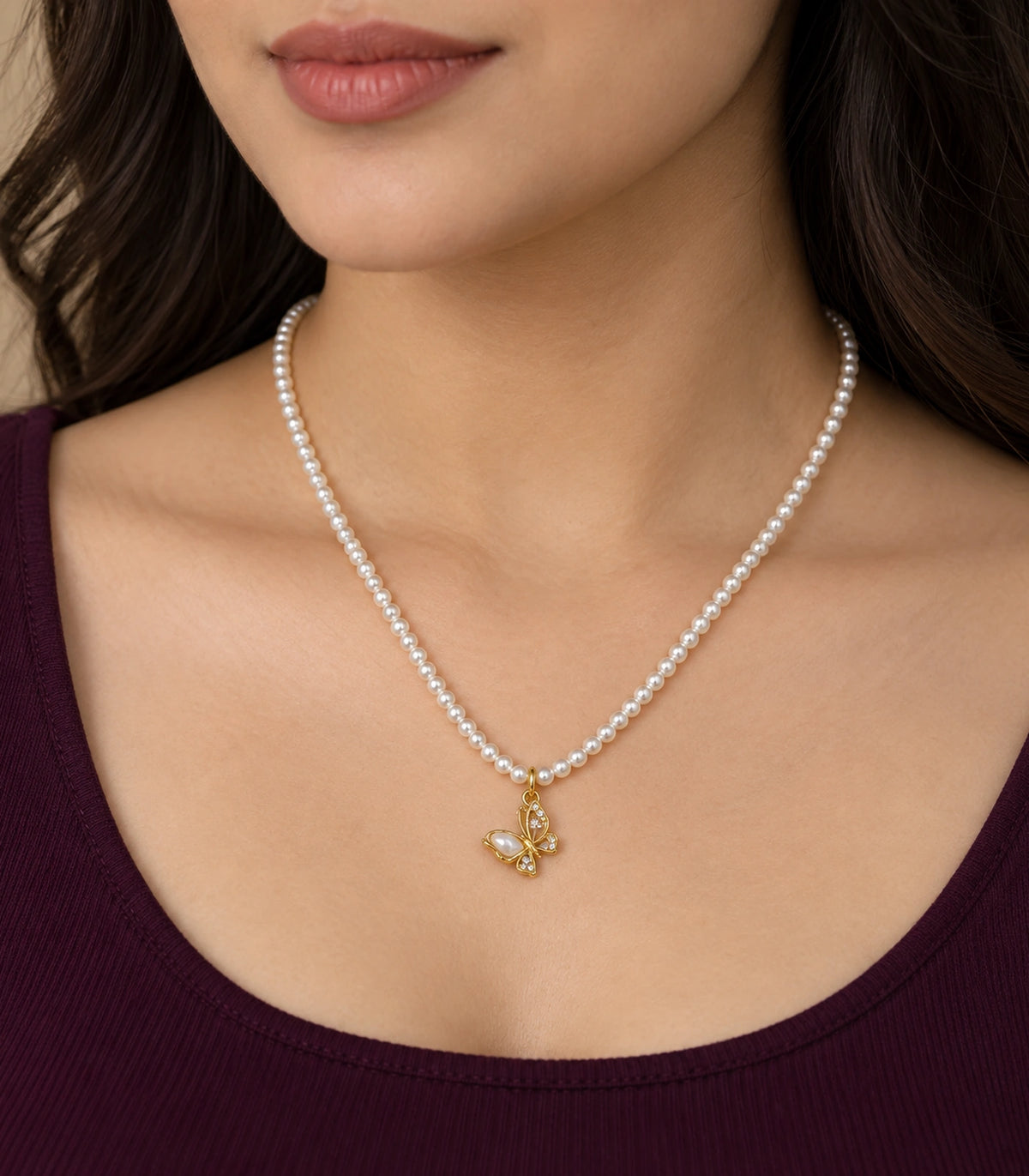 JIMIKI Gold-Tone Butterfly Pearl Necklace in Gold-tone / white, worn with a simple outfit