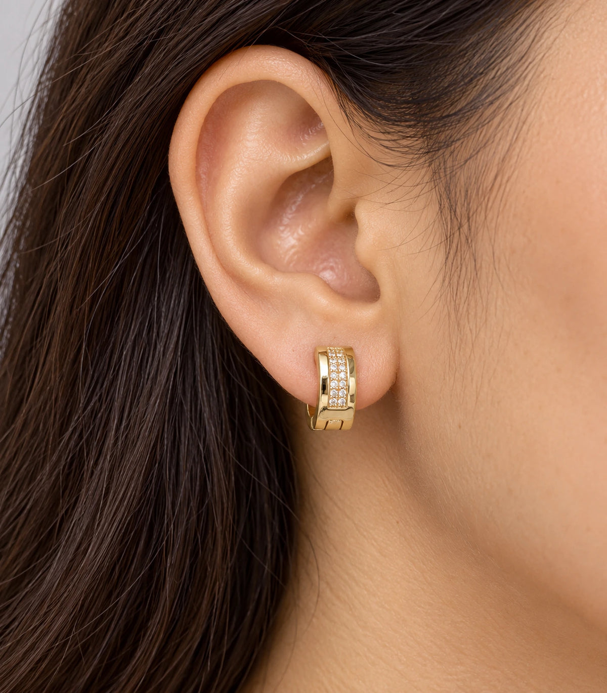 JIMIKI Gold Tone central pave strip huggie hoop earrings, worn on the ear #color_gold-tone