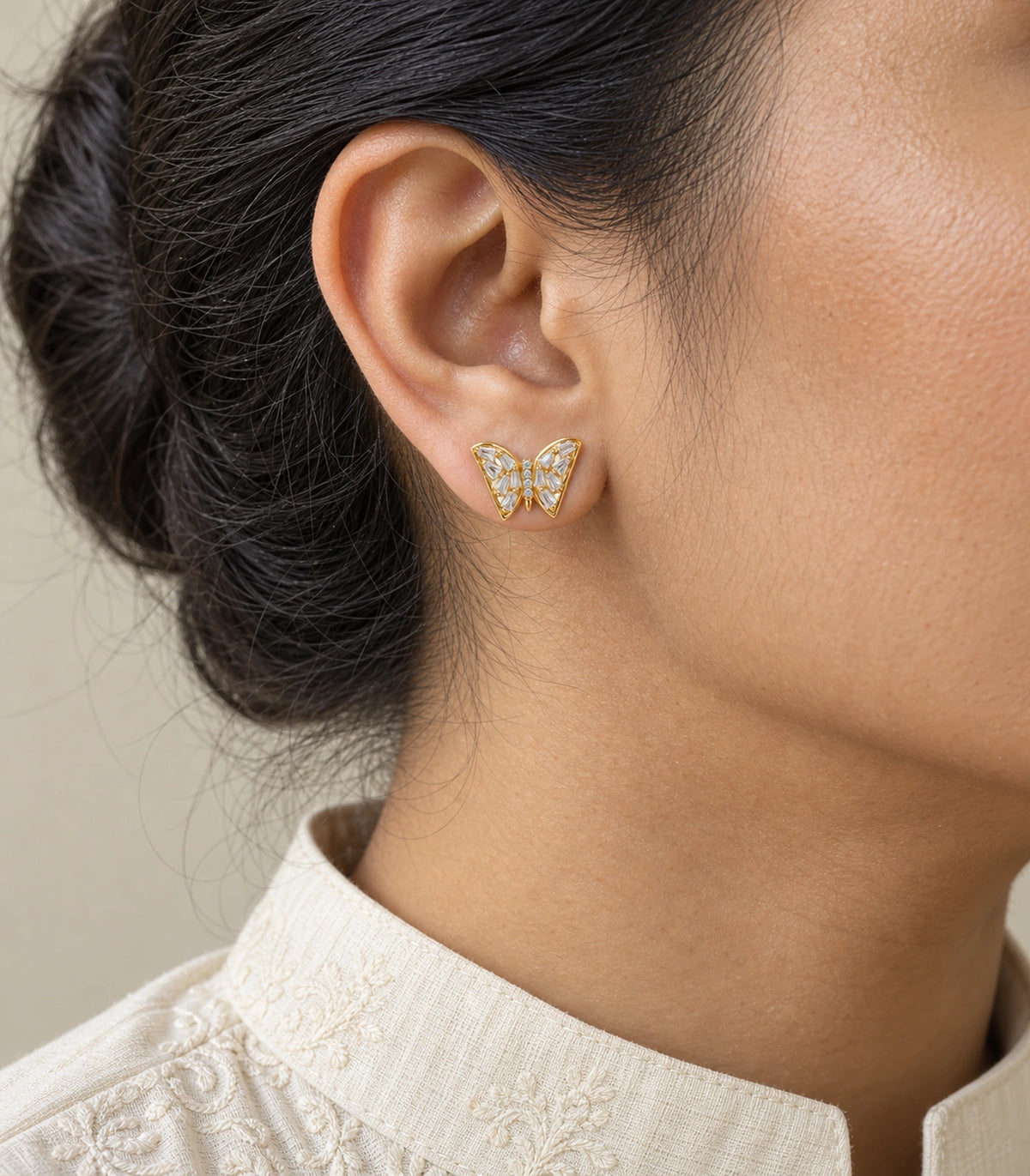 JIMIKI Gold Tone Clear Baguette Butterfly Stud Earring Pair in Gold tone, model wearing view