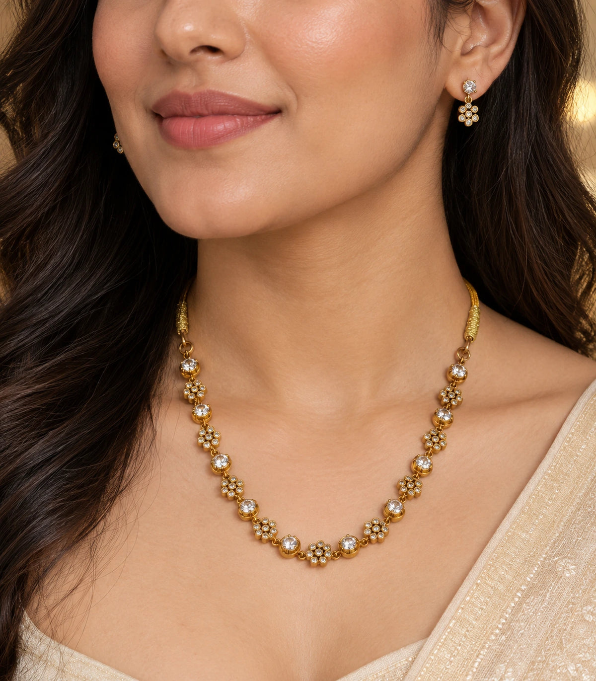 Worn detail of the gold-tone floral cluster necklace and matching earrings