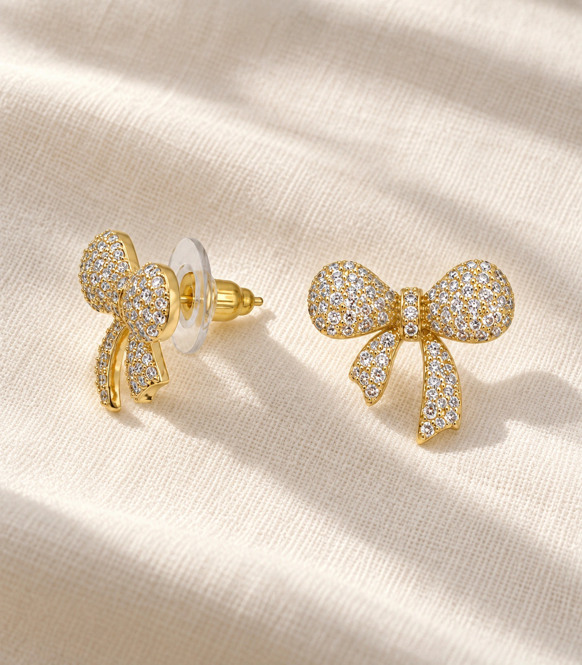 JIMIKI Pave Ribbon Bow Stud Earring Pair in Gold-tone, editorial flat lay #color_gold-tone