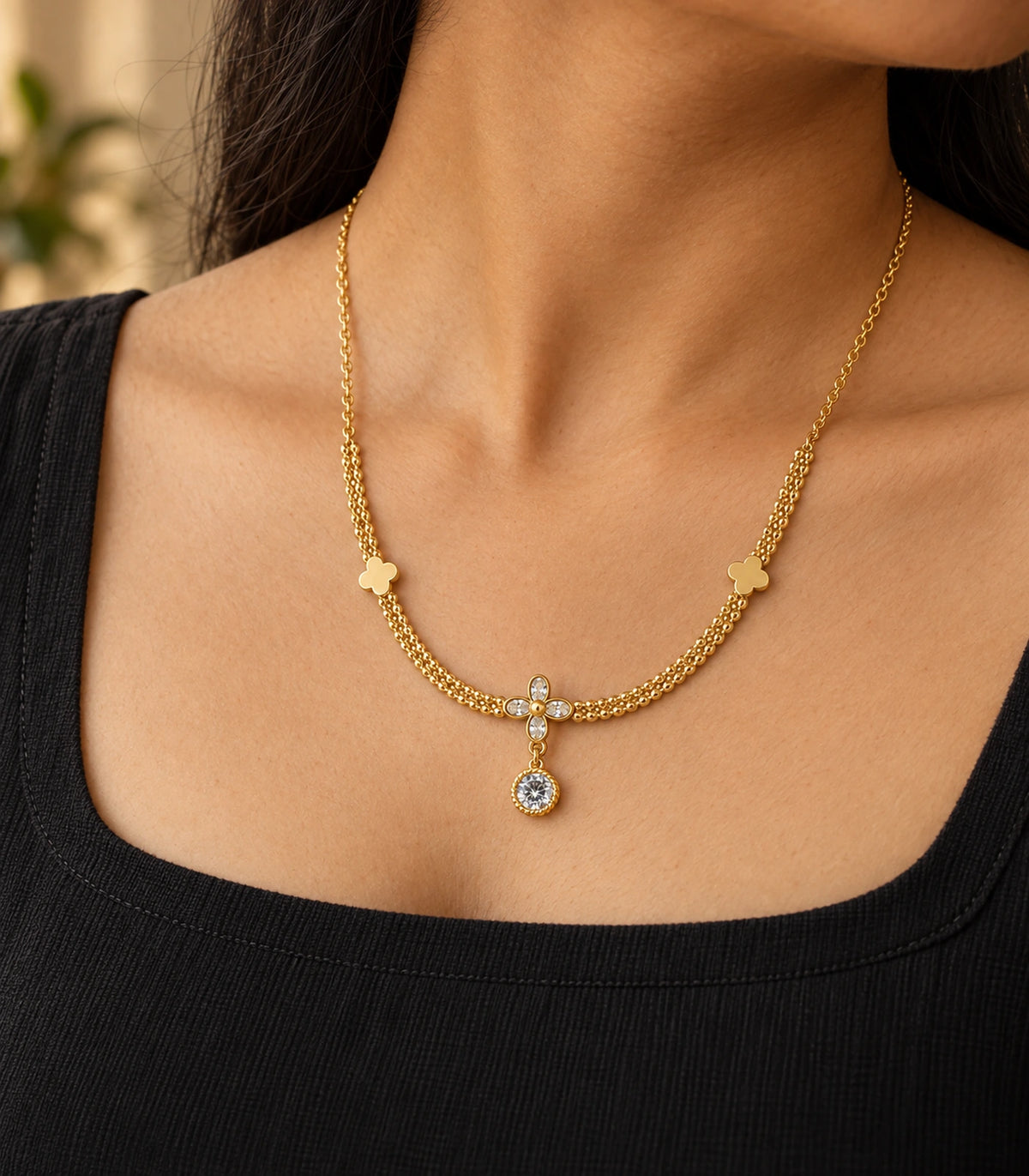 JIMIKI Clover Crystal Flower Drop Necklace in Gold Tone - editorial worn view #color_gold-tone