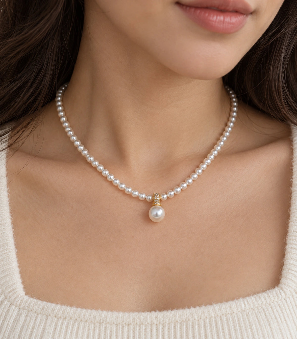 JIMIKI Gold-Tone Crystal Bail Pearl Drop Necklace in Gold-tone / white, close-up of the pendant and pearl-style strand