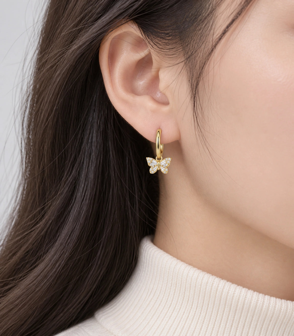 JIMIKI Crystal Butterfly Huggie Earrings in Gold / Clear, model wearing view #color_gold / clear