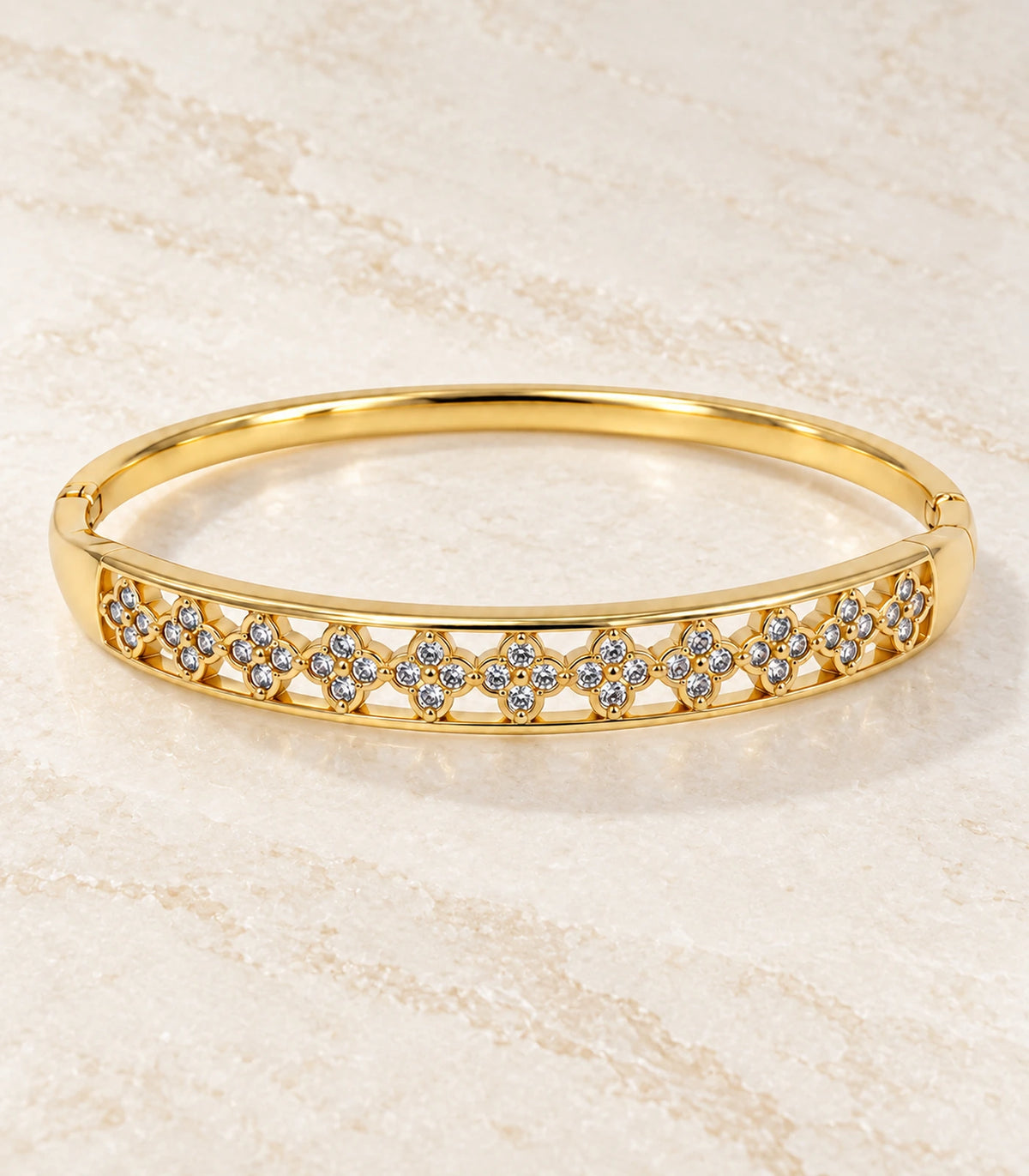 JIMIKI Gold-Tone Crystal Floral Lattice Bangle — bangle in a styled flat lay #color_gold-tone / clear