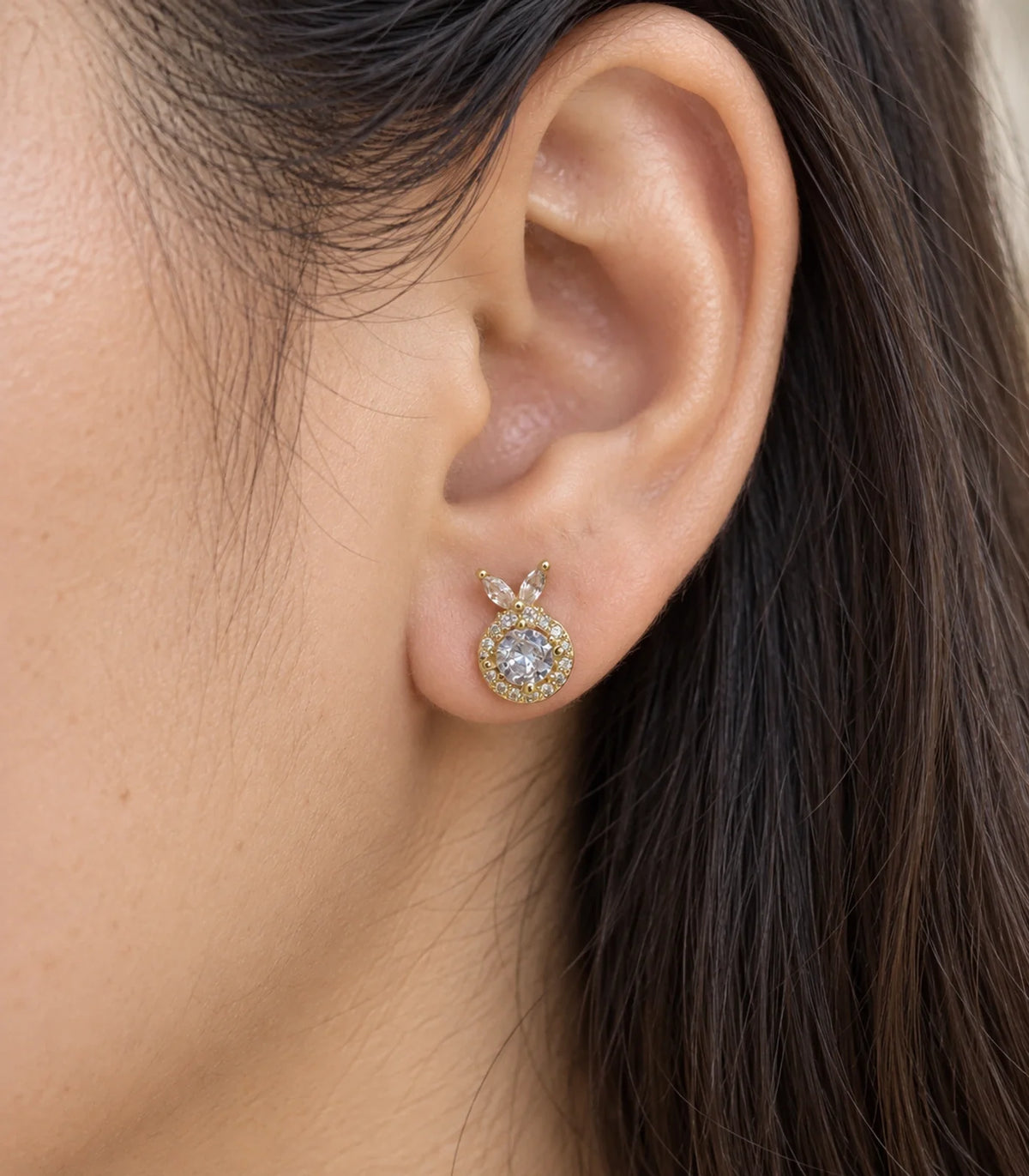 JIMIKI Crystal Halo Leaf Stud Earrings in Gold Tone - worn close-up showing earring detail #color_gold-tone