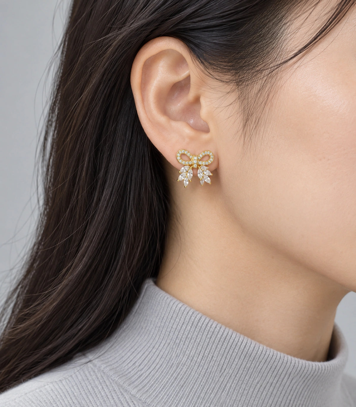JIMIKI Gold-Tone Crystal Loop Bow Stud Earrings in Gold / Clear, model wearing view