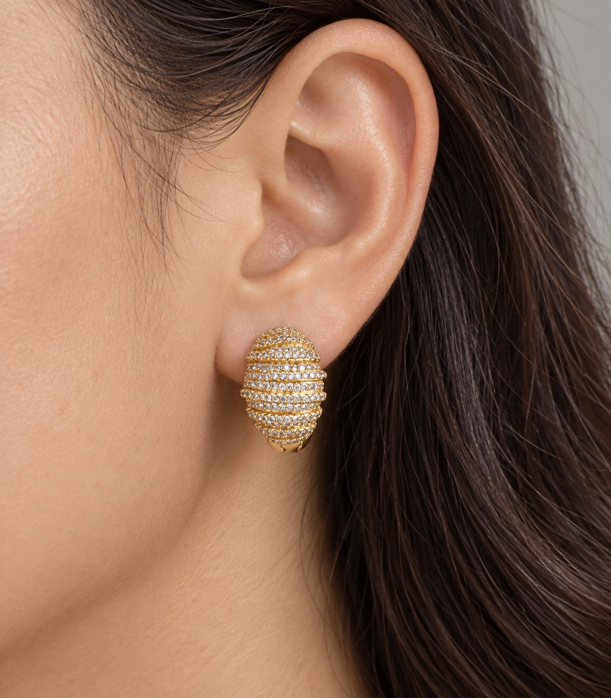 JIMIKI Crystal Ribbed Dome Huggie Earrings in Gold / Clear, close-up detail #color_gold / clear