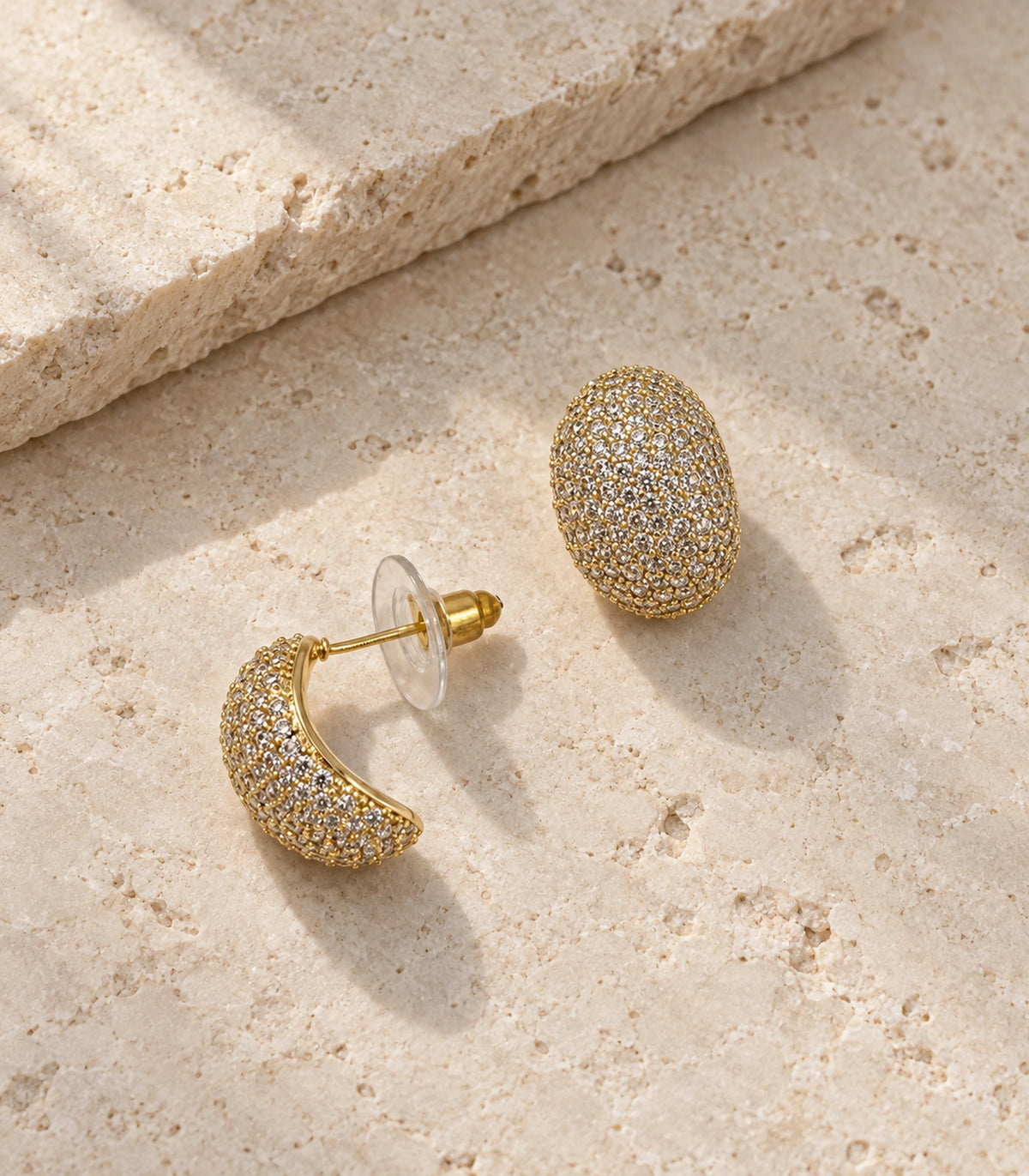 JIMIKI Domed Pave Oval Stud Earring Pair in Gold Tone, editorial flat lay #color_gold tone