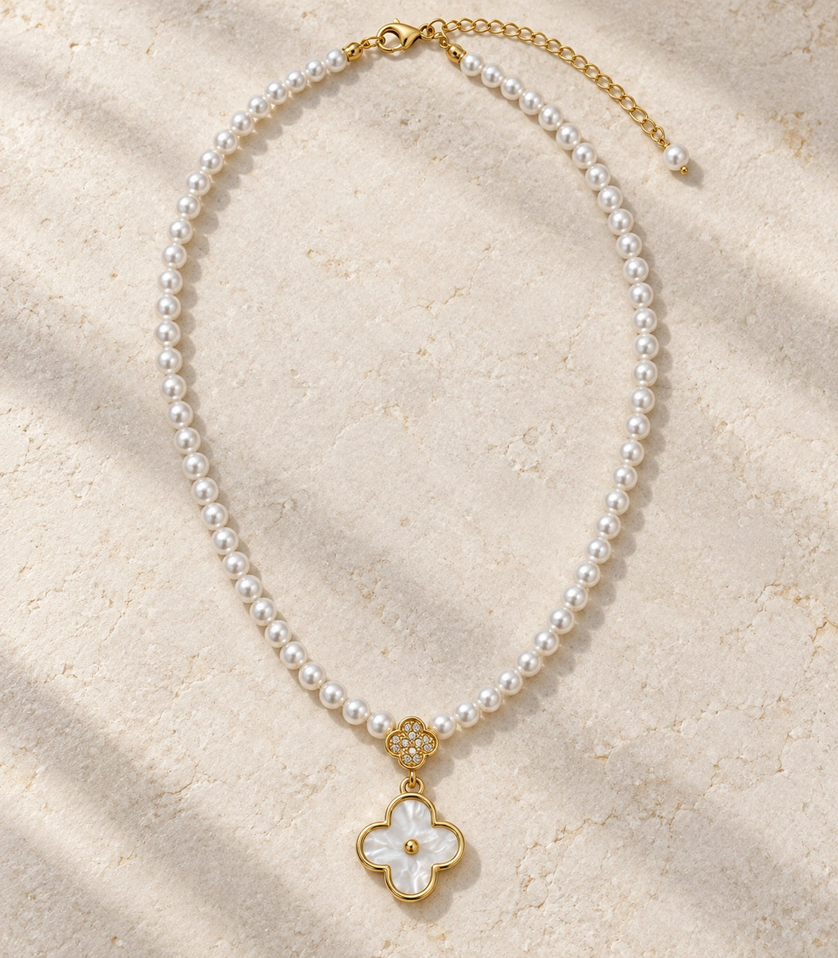 JIMIKI Gold Tone Double Clover White Inlay Pearl Necklace in Gold / White, editorial flat lay