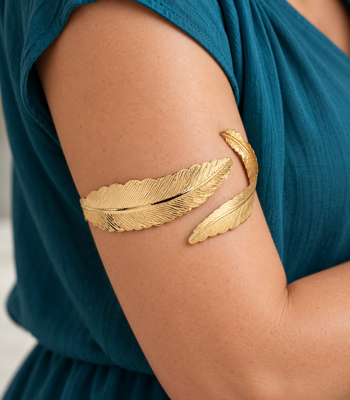 Close view of the double feather arm cuff showing engraved quills and barbs