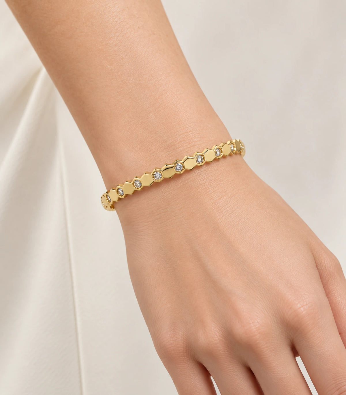 JIMIKI Gold-Tone Faceted Bezel Crystal Bangle — worn on the wrist #color_gold-tone / clear