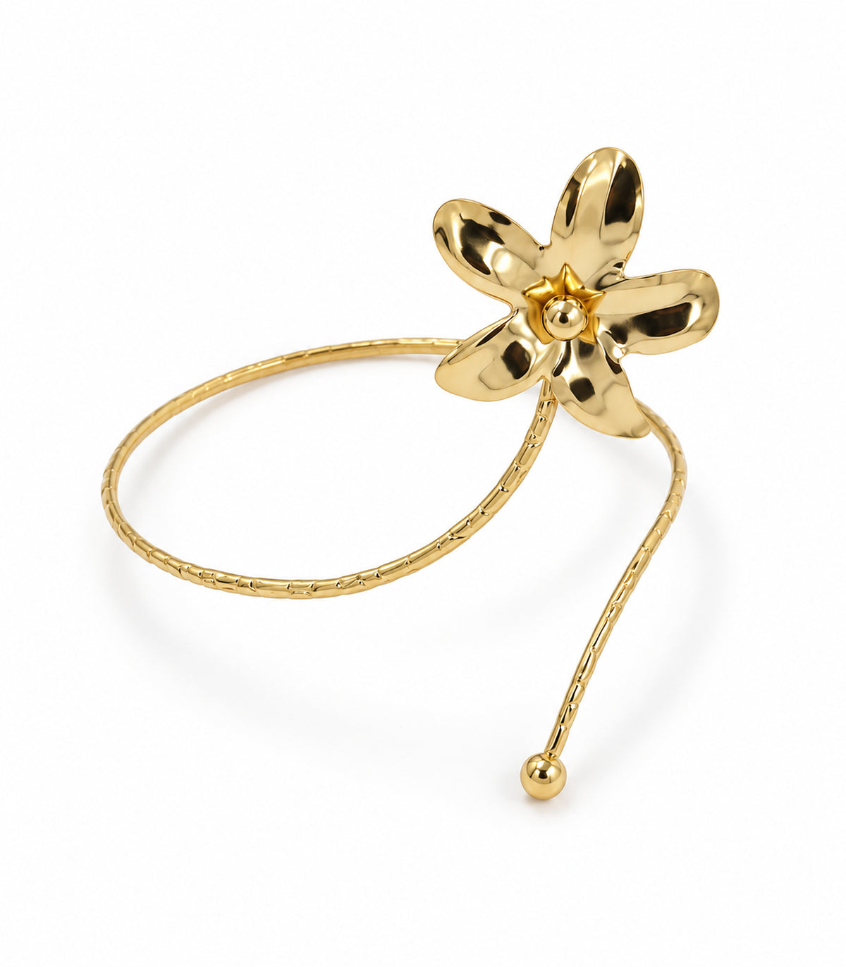 Single gold-tone arm cuff with five-petal flower, bead centre, segmented band and ball tip on white
