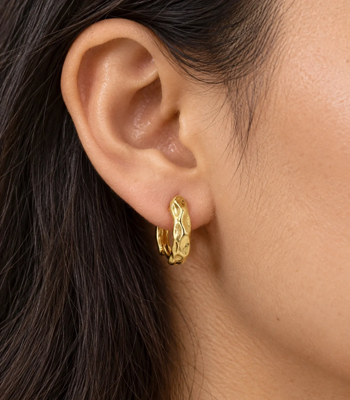 JIMIKI Gold Tone Hammered Hoop Earrings, worn closeup detail #color_gold-tone