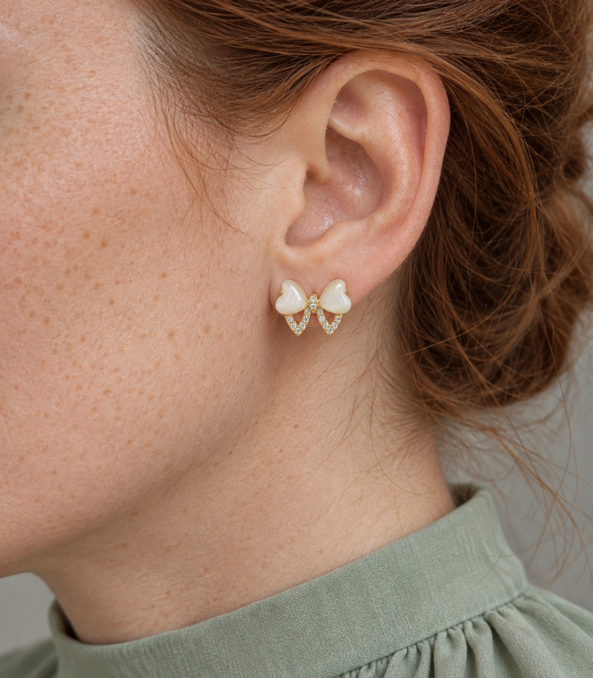 JIMIKI Gold Tone Ivory Heart Bow Crystal Stud Earring Pair in Gold tone, close-up detail