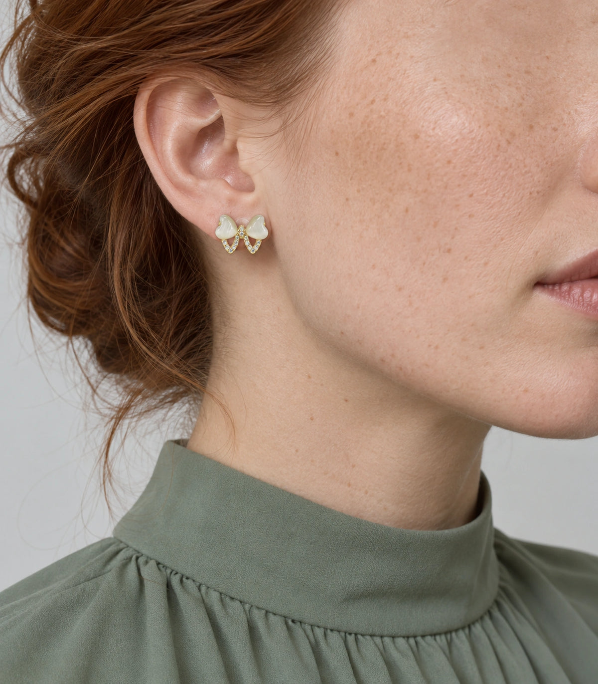 JIMIKI Gold Tone Ivory Heart Bow Crystal Stud Earring Pair in Gold tone, model wearing view
