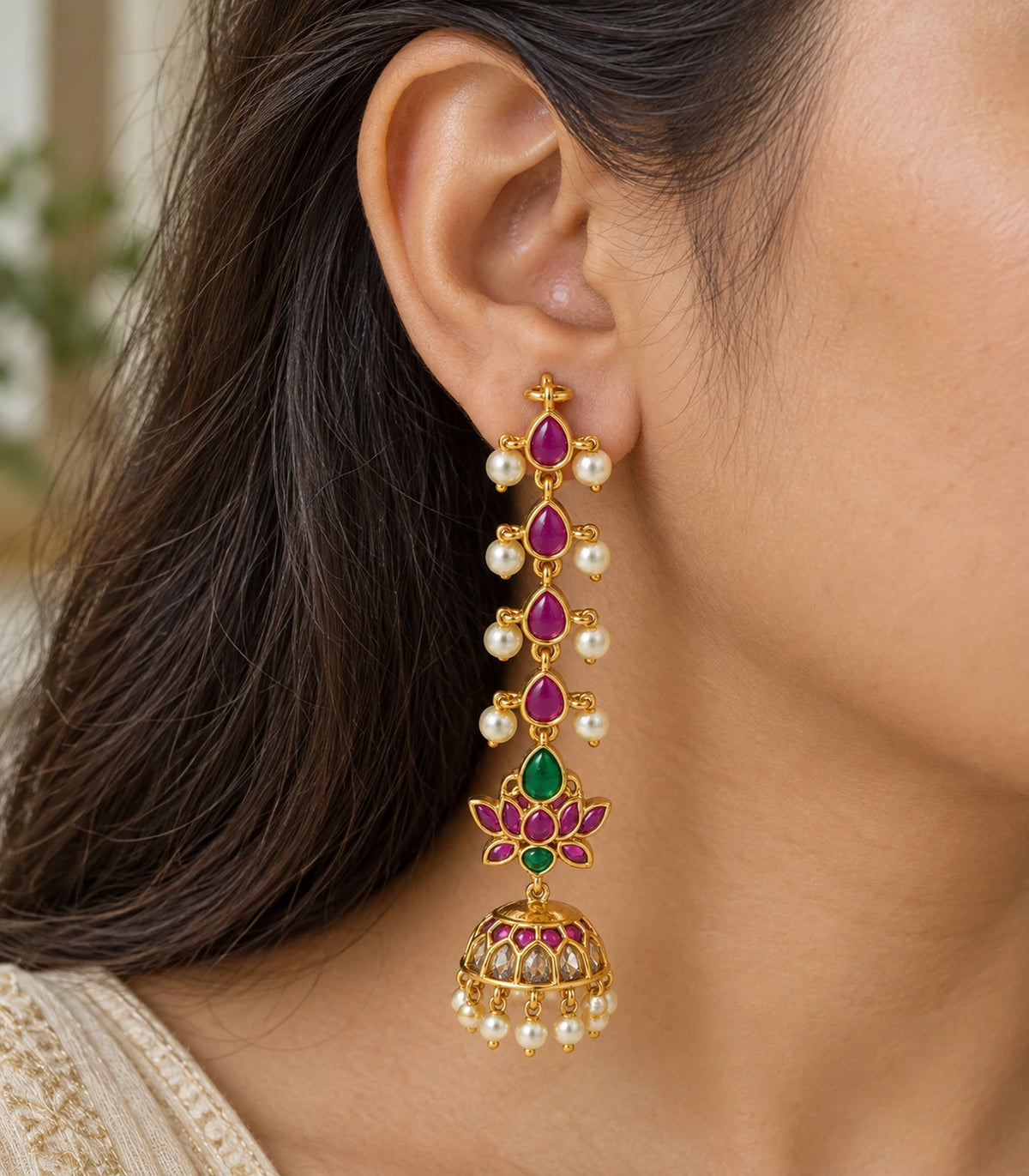 Close view of magenta and green lotus jhumka earring with pearl-style accents
