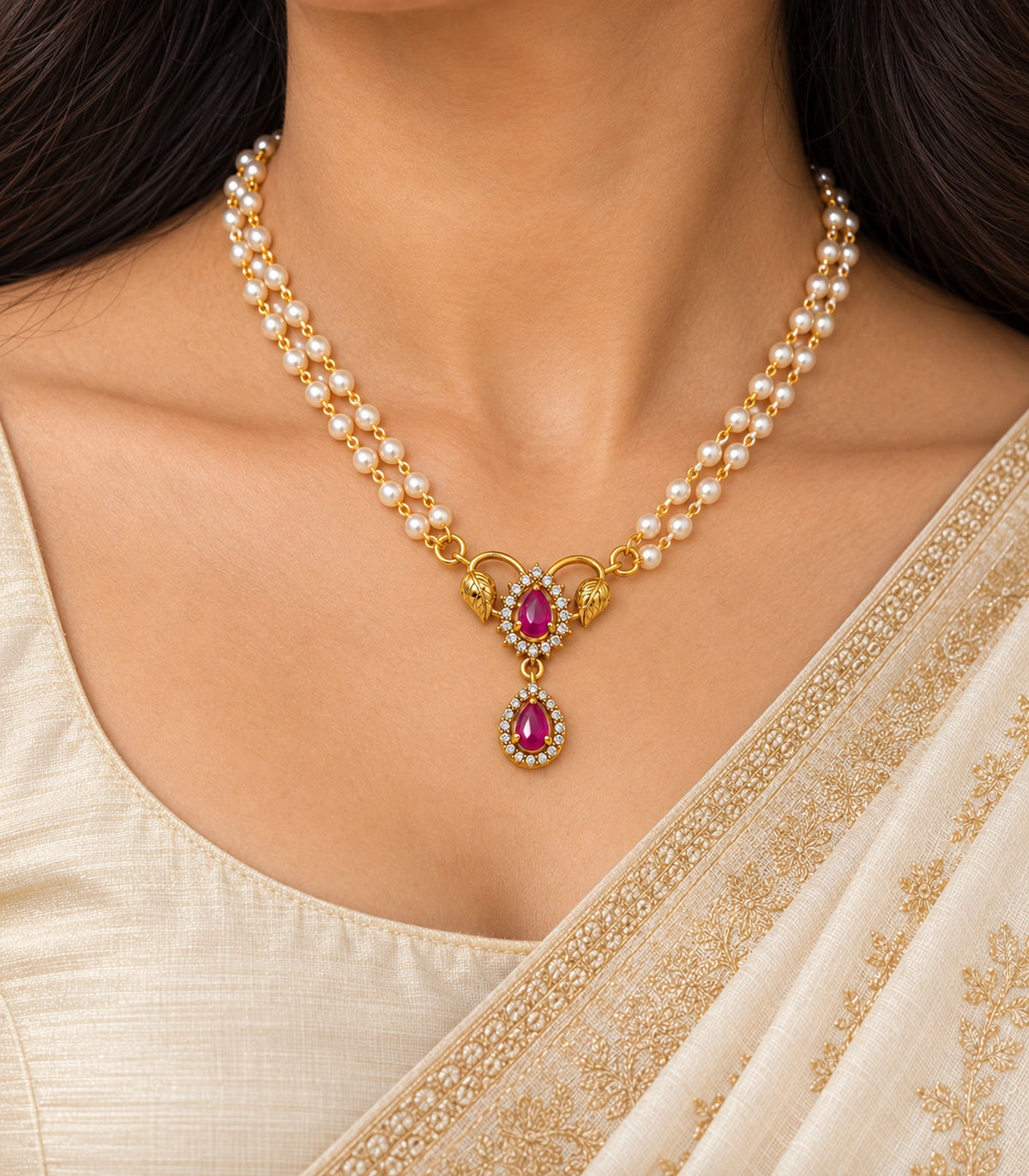 Close view of the worn magenta necklace showing both gold leaves, two teardrop accents and clear-stone surrounds.