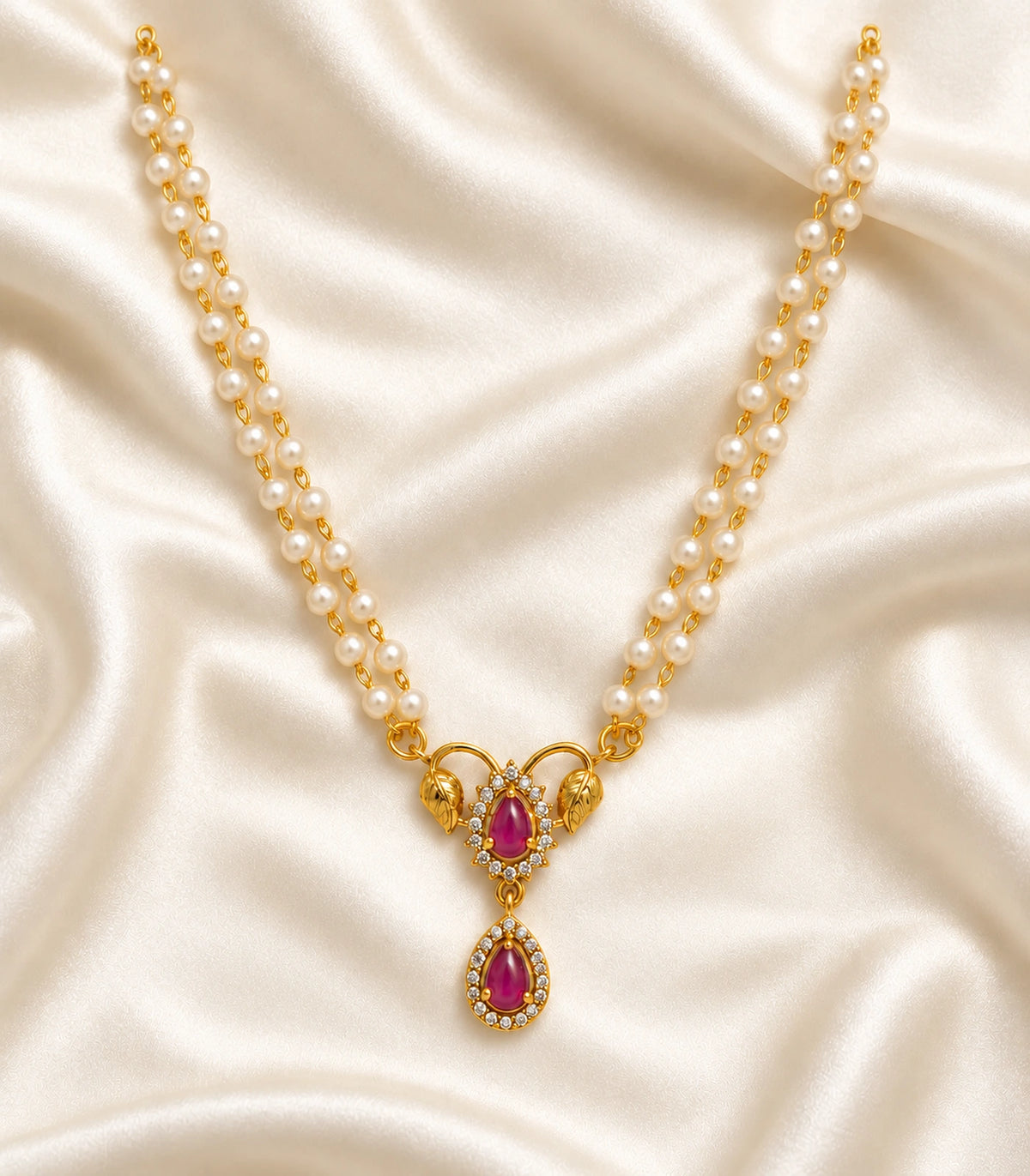 One magenta leaf pendant necklace with twin white bead strands arranged completely on ivory satin; no earrings.