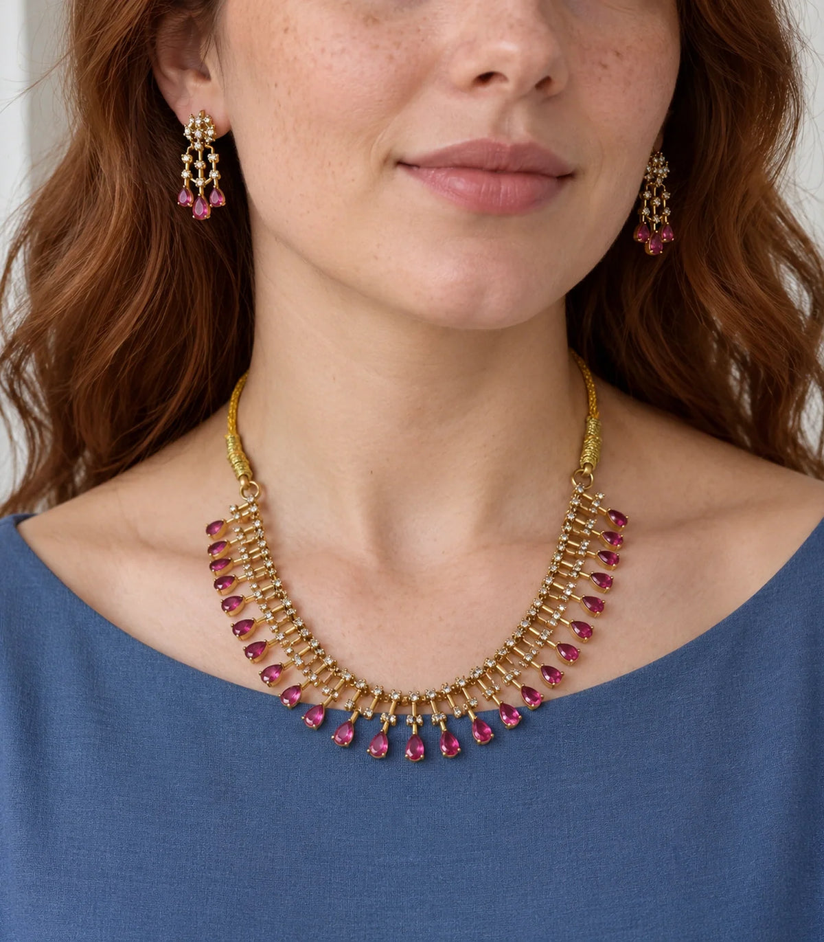 Magenta teardrop fringe necklace and matching earrings shown worn with a blue outfit #Color_Magenta