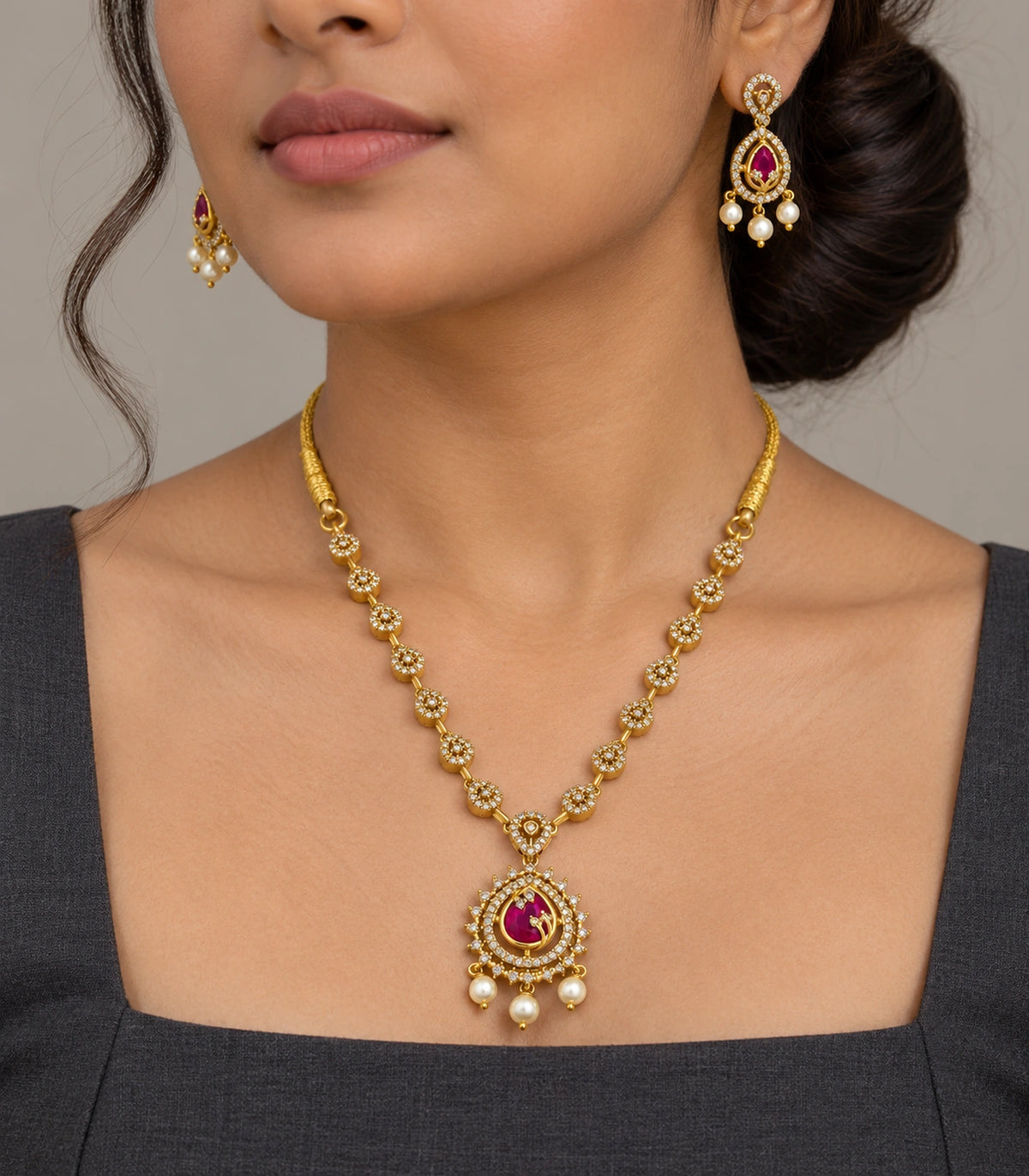 Magenta teardrop pendant necklace set worn with a dark outfit