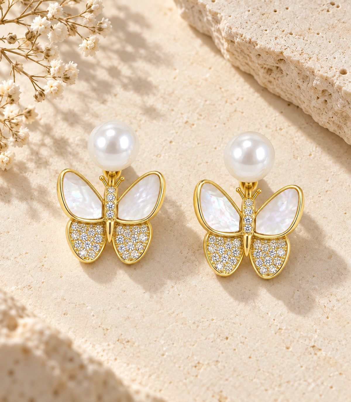 JIMIKI Gold-Tone Pearlescent Butterfly Pearl-Style Stud Earrings in Pearl White / Gold, editorial flat lay