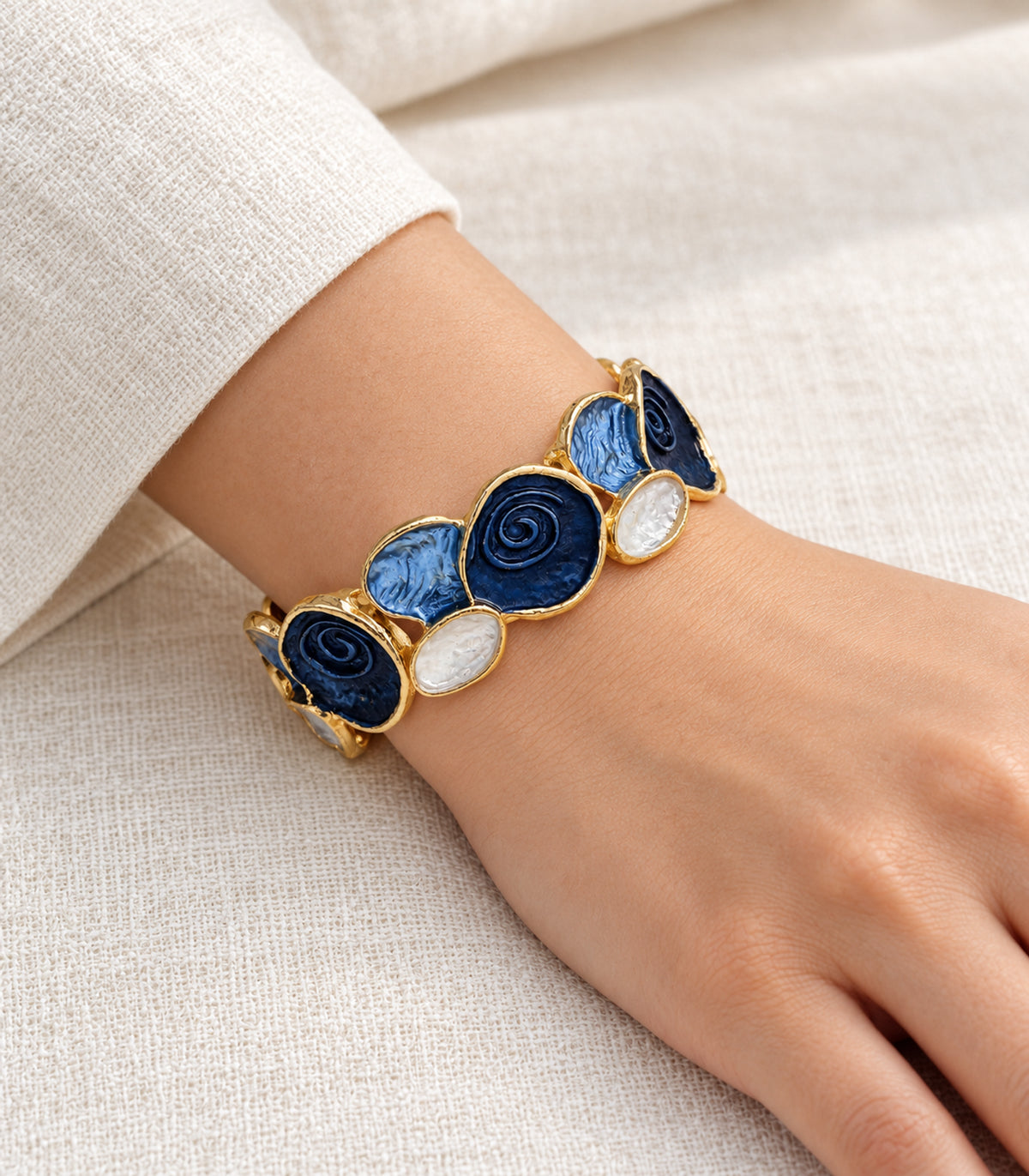 Gold-tone navy spiral and blue fan panel bracelet — model view