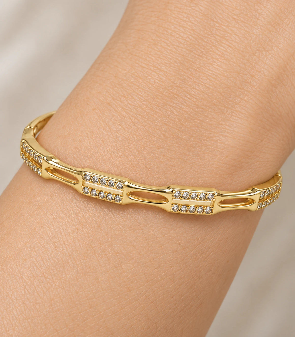 JIMIKI Gold-Tone Open Link Double Row Crystal Bangle — close-up of the bangle worn on the wrist #color_gold-tone / clear