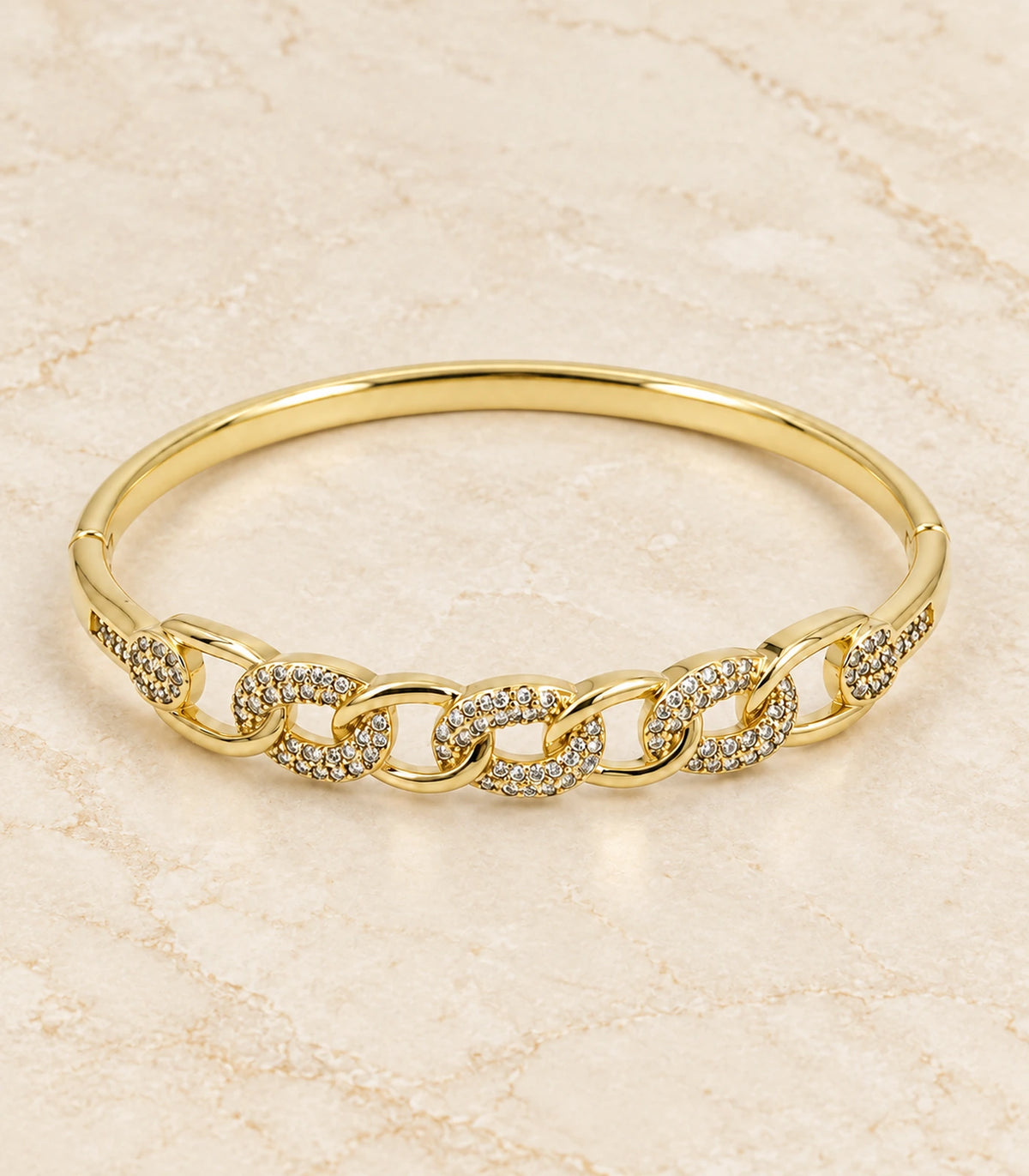 JIMIKI Gold-Tone Pavé Chain Link Bangle — bangle in a styled flat lay #color_gold-tone / clear