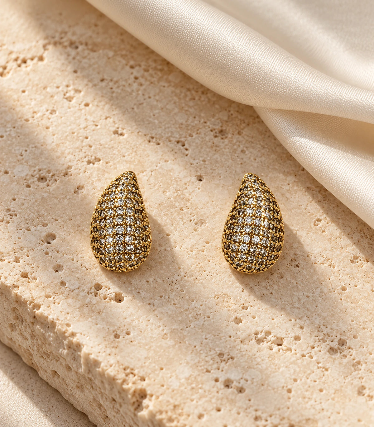 JIMIKI Gold Tone Pave Teardrop Stud Earrings - editorial-flatlay #color_gold-tone