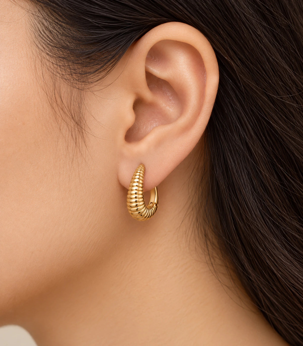 JIMIKI Ribbed Teardrop Hoop Earrings in Gold Tone - model #color_gold-tone