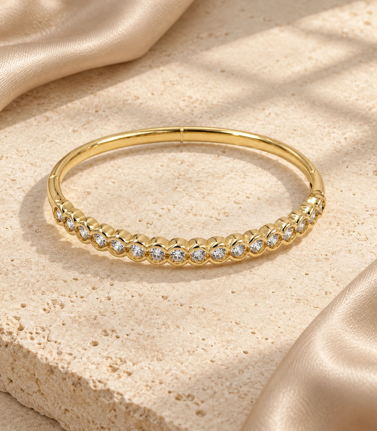 JIMIKI Gold-Tone Scalloped Bezel Crystal Bangle — bangle in a styled flat lay #color_gold-tone / clear