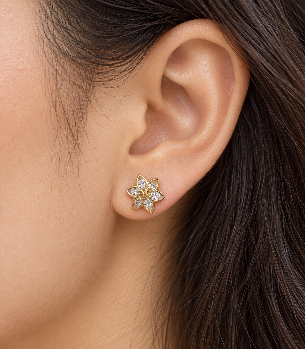 JIMIKI Gold-Tone Six-Petal Crystal Flower Stud Earrings in Gold / Clear, close-up detail