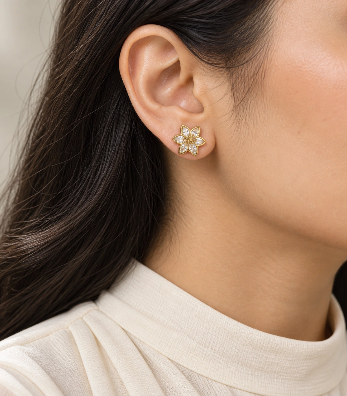 JIMIKI Gold-Tone Six-Petal Crystal Flower Stud Earrings in Gold / Clear, model wearing view