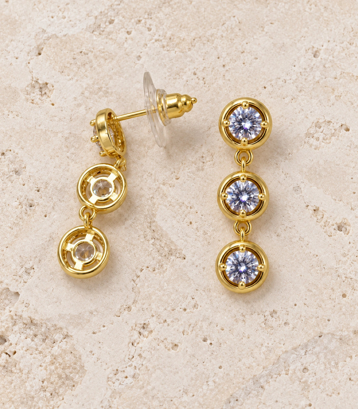 JIMIKI Three Round Crystal Drop Earring Pair in Gold tone/Clear, editorial flat lay #color_gold tone/clear