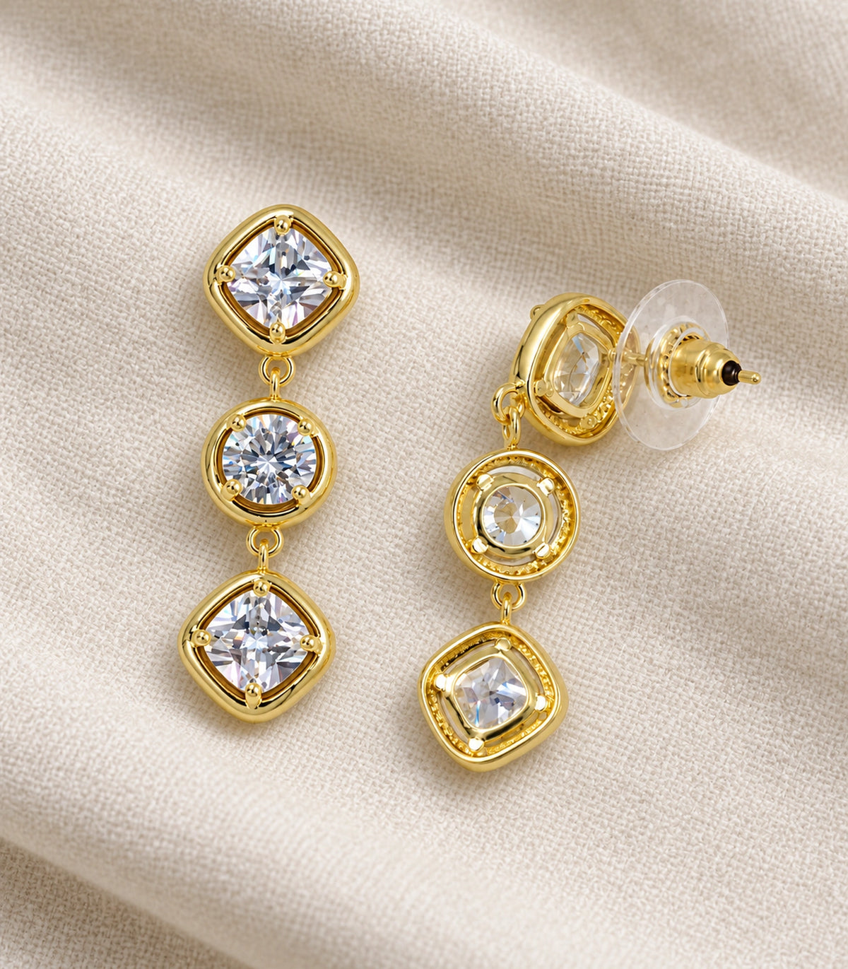 JIMIKI Three Stone Crystal Drop Earring Pair in Gold tone, editorial flat lay #color_gold tone