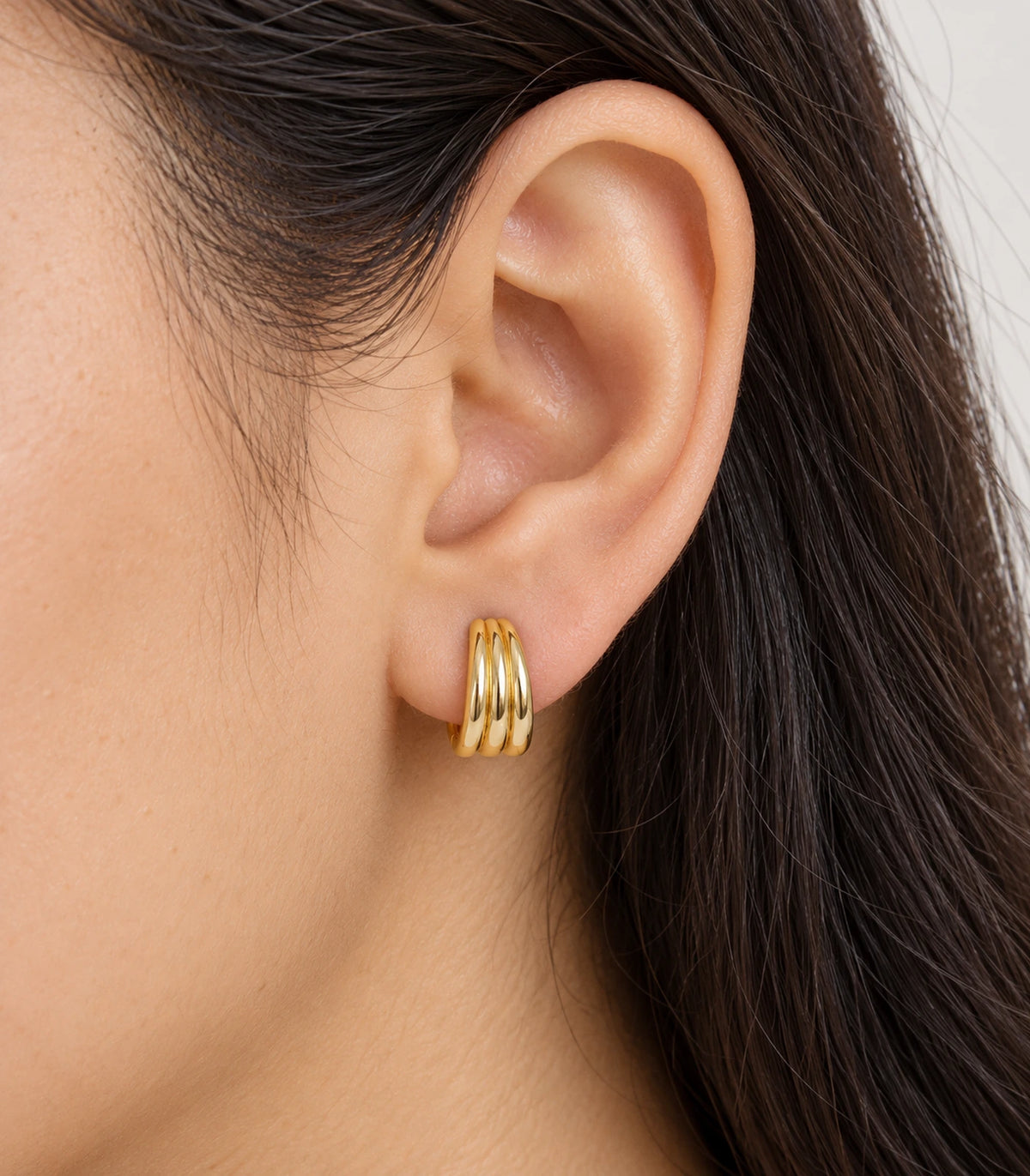 JIMIKI Triple-Ridge Huggie Hoop Earrings in Gold Tone - model #color_gold-tone