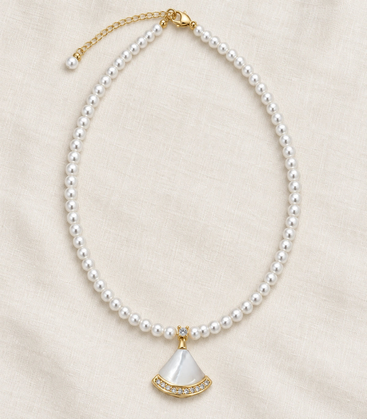 JIMIKI Gold Tone White Fan Crystal Pearl Style Necklace in Gold tone / white, editorial flat lay